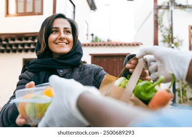 Volunteer handing fresh produce to a neighbor